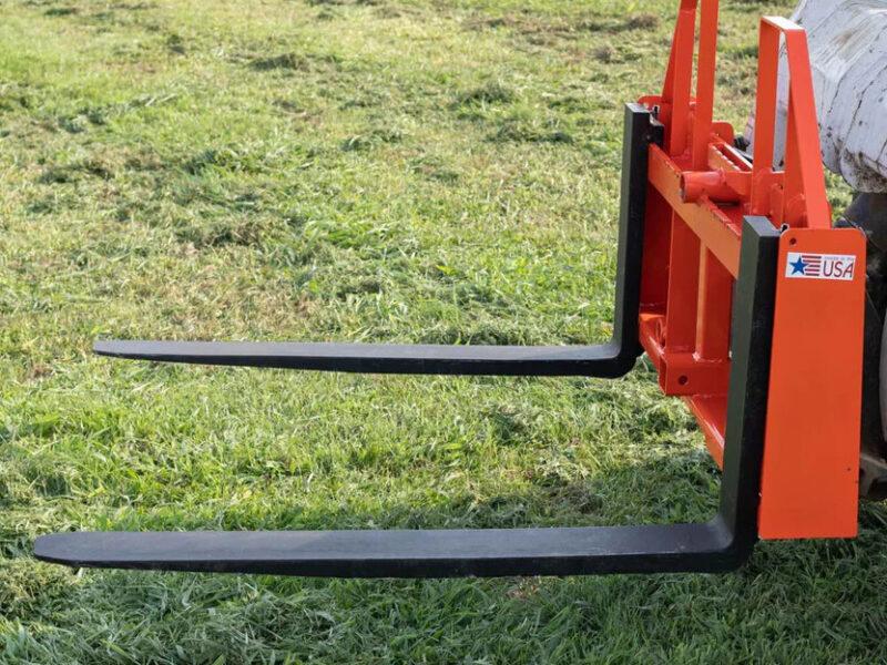 Track loader with forks handling construction supplies
