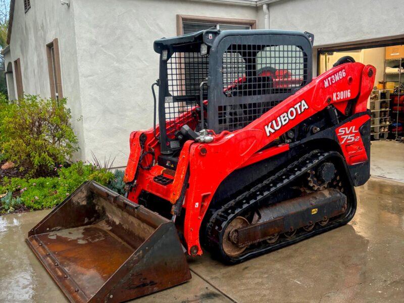 Iron Coast's Kubota SVL75-2 with the smooth bucket resting on the ground