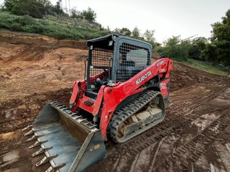 Kubota SVL75-2 track loader with a toothed bucket on a dirt grading job